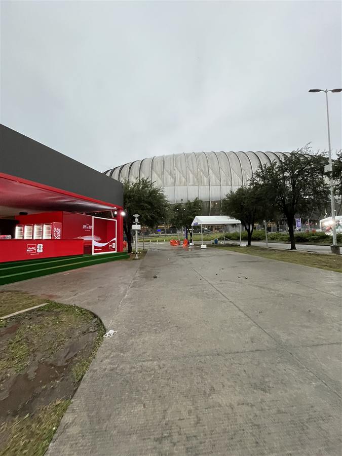 Carpa oficial Coca-Cola FIFA World Cup con el letrero del partido Japón vs Túnez, afuera del Estadio Monterrey