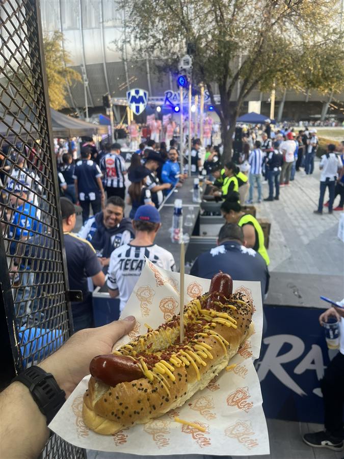 Hotdog XL sostenido en las gradas durante un partido de Rayados