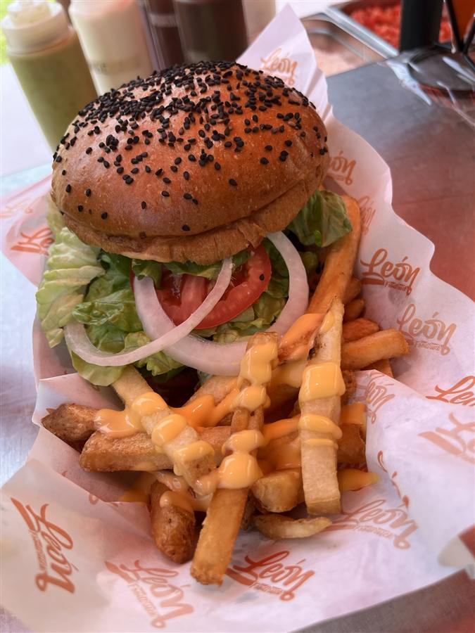 Hamburguesa con pan de ajonjolí negro y papas con queso de Léon Foodtruck